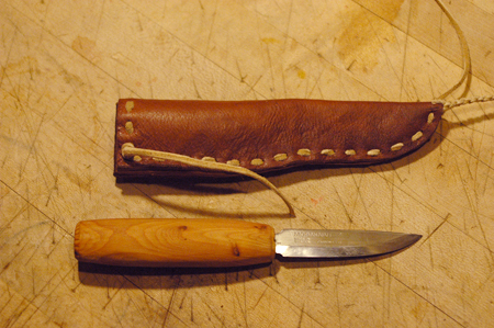 My friend brought over this knife to make a sheath. I've got an outline made for a video on knife handle design and had to entirely reshape the handle first, which turned into a video segment. The sheath is made from 4 different leathers, stiff bark tanned wild boar on the inside, soft goat on the outside, a horse hide welt to protect the stitching and braintanned buckskin sewing thong. It turned out pretty sweet. I'm not a big fan of this mora style of blade for general purpose knives, but that puts me in a minority among the primitive skills crowd.